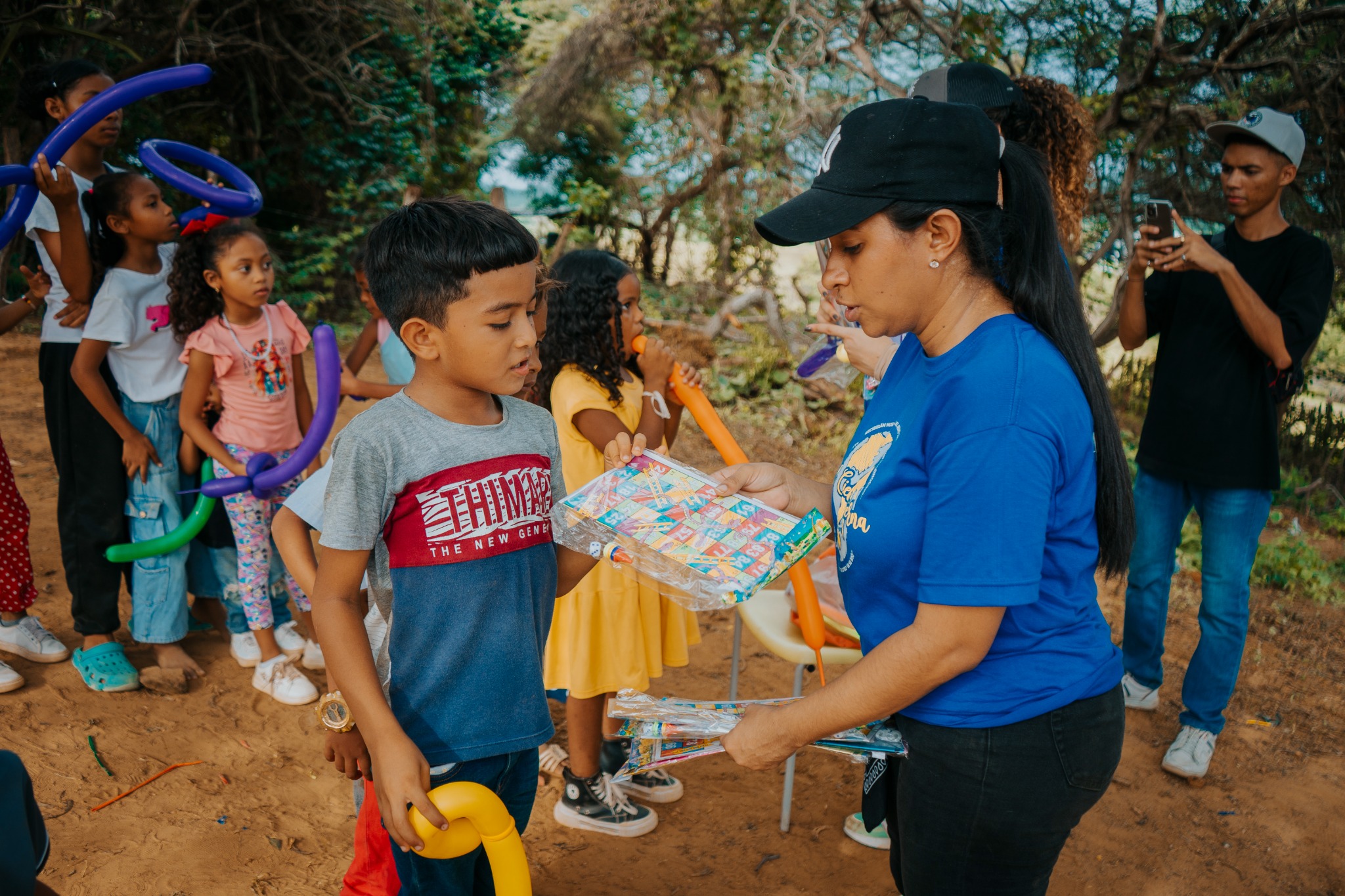 Voluntaria de la Fundación El Cielo Gobierna compartiendo materiales con niños de la comunidad